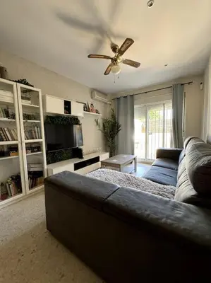a living room with a couch and a ceiling fan at Jerez Rincón de Chloe y Julieta in Jerez de la Frontera