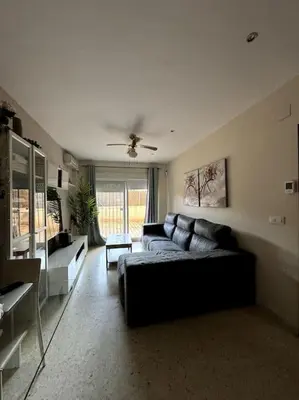 a living room with a couch and a ceiling fan at Jerez Rincón de Chloe y Julieta in Jerez de la Frontera
