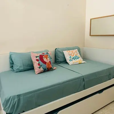 a blue couch with two pillows on it at Jerez Rincón de Chloe y Julieta in Jerez de la Frontera