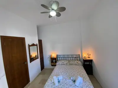 a bedroom with a bed and a ceiling fan at Apartamento Crucero 2, la Jara in Sanlúcar de Barrameda