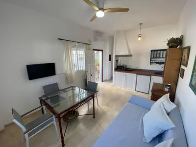 a living room with a blue couch and a glass table at Apartamento Crucero 2, la Jara in Sanlúcar de Barrameda