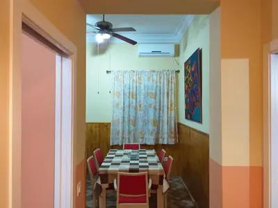 a dining room with a table with chairs and a ceiling fan at Casa araceli in Chipiona