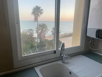 a kitchen window with a view of the beach at Primera Línea Playa el Manantial in El Puerto de Santa María