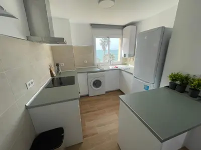 a kitchen with a refrigerator and a washing machine at Primera Línea Playa el Manantial in El Puerto de Santa María