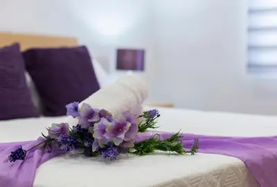 a bouquet of purple flowers on a bed at Playa Santa Maria Moderno 3 Rooms in Cádiz