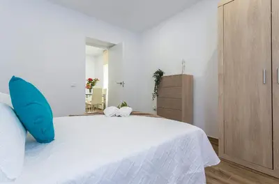 a bedroom with a large white bed with blue pillows at Playa Santa Maria Moderno 3 Rooms in Cádiz