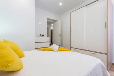 a bedroom with a large white bed with yellow pillows at Playa Santa Maria Moderno 3 Rooms in Cádiz