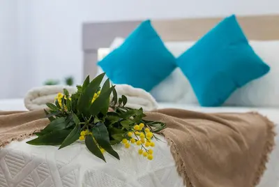 a flower arrangement on a bed with blue pillows at Playa Santa Maria Moderno 3 Rooms in Cádiz