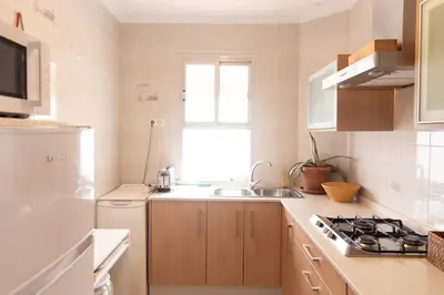 a white kitchen with a sink and a stove at Hogar del Sur by Gades Gestión in Cádiz