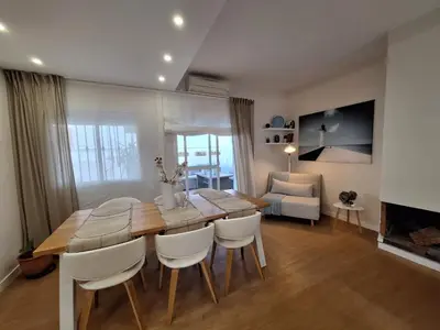 a dining room with a wooden table and white chairs at Casa Las Golondrinas in Rota