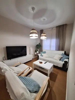 a living room with a white couch and a tv at Casa Las Golondrinas in Rota