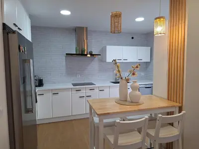 a kitchen with a table with a vase of flowers on it at Casa Las Golondrinas in Rota