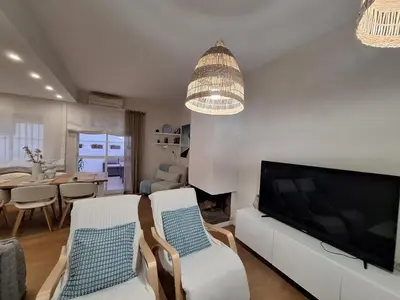 a living room with a large television and a dining room at Casa Las Golondrinas in Rota