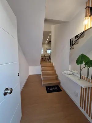 a hallway with stairs with a home sign on the floor at Casa Las Golondrinas in Rota