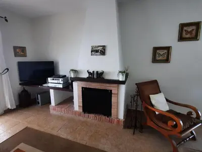a living room with a fireplace and a television at »Casa Conil Buena Vista« in Conil de la Frontera