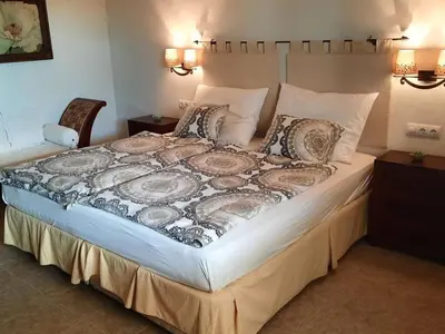 a large bed in a bedroom with two chairs at »Casa Conil Buena Vista« in Conil de la Frontera