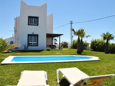 a villa with a swimming pool in front of a house at Torre Andaluz Villa con piscina 2 habitaciones in Cádiz