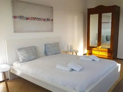 a white bed with two pillows and a mirror at Torre Andaluz Villa con piscina 2 habitaciones in Cádiz