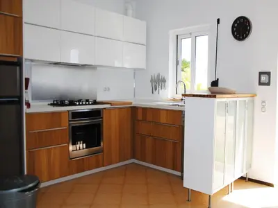 a kitchen with wooden cabinets and white appliances at Torre Andaluz Villa con piscina 2 habitaciones in Cádiz