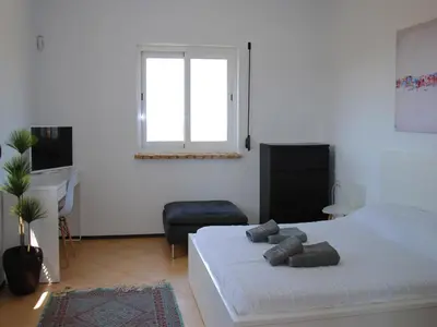 a bedroom with a bed and a desk and a window at Torre Andaluz Villa con piscina 2 habitaciones in Cádiz