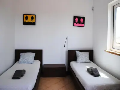 two beds in a room with white walls at Torre Andaluz Villa con piscina 2 habitaciones in Cádiz