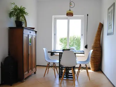 a dining room with a table and chairs and a window at Torre Andaluz Villa con piscina 2 habitaciones in Cádiz