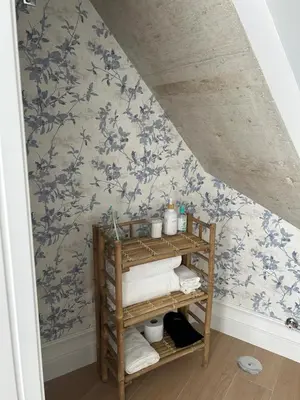 a bathroom with blue floral wallpaper and a shelf with towels at El Taller in Jerez de la Frontera