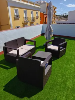 two chairs and an umbrella on the grass on a roof at Casa Palacio La Lola y Olé Gran Terraza in Jerez de la Frontera