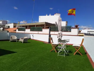 a patio with green grass and chairs on a roof at Casa Palacio La Lola y Olé Gran Terraza in Jerez de la Frontera