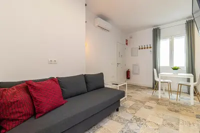 a living room with a gray couch and a table at Casa Palacio La Lola y Olé Gran Terraza in Jerez de la Frontera
