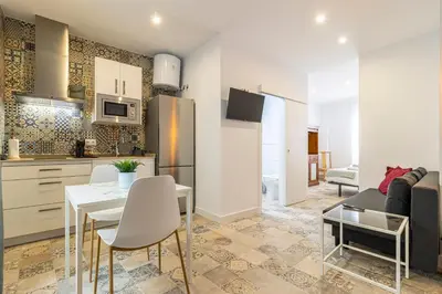 a kitchen and living room with a table and chairs at Casa Palacio La Lola y Olé Gran Terraza in Jerez de la Frontera
