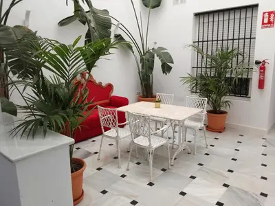 a table and chairs in a room with plants at Casa Palacio La Lola y Olé Gran Terraza in Jerez de la Frontera