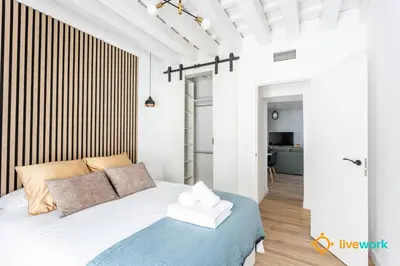 a bedroom with a bed with a blue blanket at Buenos Aires by LiveWork in Cádiz
