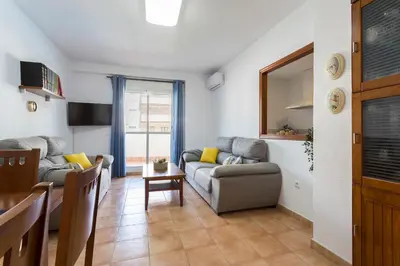a living room with a couch and a table at Laguna 3 Rooms Piscina in Chipiona