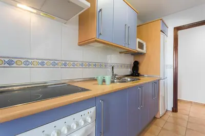 a kitchen with blue cabinets and a sink at Laguna 3 Rooms Piscina in Chipiona