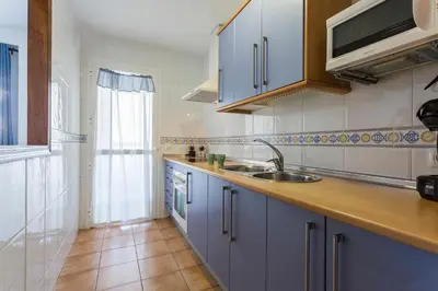 a kitchen with blue cabinets and a sink at Laguna 3 Rooms Piscina in Chipiona