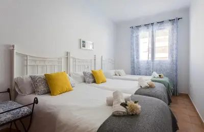 a bedroom with two beds with yellow and blue pillows at Laguna 3 Rooms Piscina in Chipiona