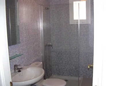 a bathroom with a shower and a sink and a toilet at Apartamento JARDINES DE BAJO GUIA in Sanlúcar de Barrameda