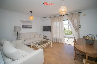 a living room with a white couch and a table at El Anfitrión - Casa Dunas in Sanlúcar de Barrameda