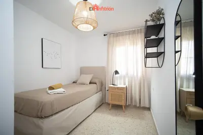 a small bedroom with a bed and a desk at El Anfitrión - Casa Dunas in Sanlúcar de Barrameda