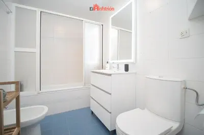 a white bathroom with a toilet and a sink at El Anfitrión - Casa Dunas in Sanlúcar de Barrameda