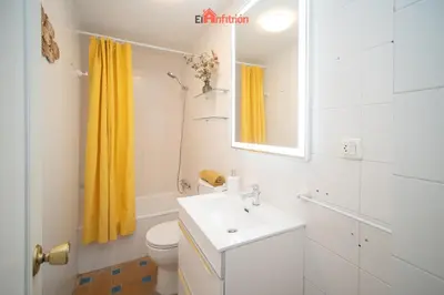 a bathroom with a sink and a yellow shower curtain at El Anfitrión - Casa Dunas in Sanlúcar de Barrameda