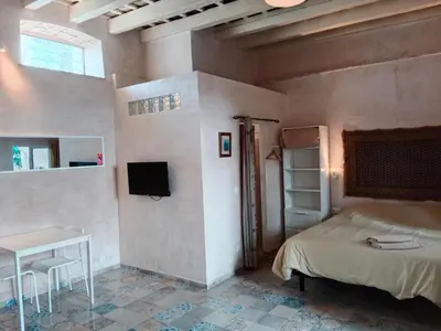 a bedroom with a bed and a tv on the wall at Casa Florinda #4 in Jerez de la Frontera