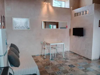 a living room with a table and a tv at Casa Florinda #4 in Jerez de la Frontera