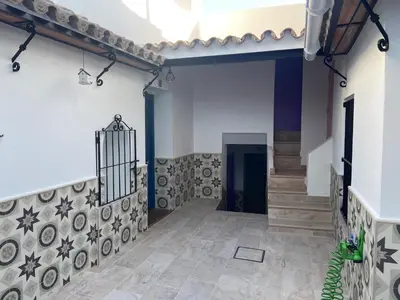a hallway of a house with a staircase and tile floors at La Pequeña Morada in Arcos de la Frontera
