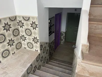 a stairway with a green door and a purple door at La Pequeña Morada in Arcos de la Frontera
