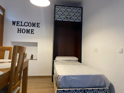 a room with two beds and a welcome home sign at La Pequeña Morada in Arcos de la Frontera