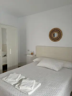 a white bed with two towels on top of it at Asís 20.7 in Medina Sidonia