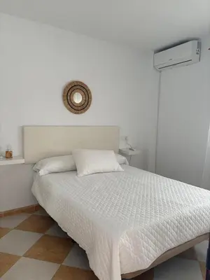 a bedroom with a bed with a white bedspread at Asís 20.7 in Medina Sidonia