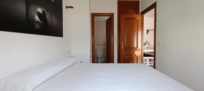 a bedroom with a bed and a television on the wall at Apartamento atico Terraza Centro in El Puerto de Santa María